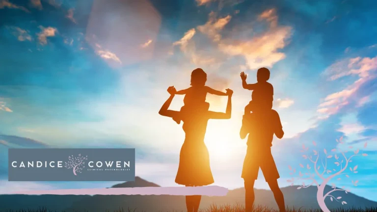 Parents carrying their children on their shoulders at sunset