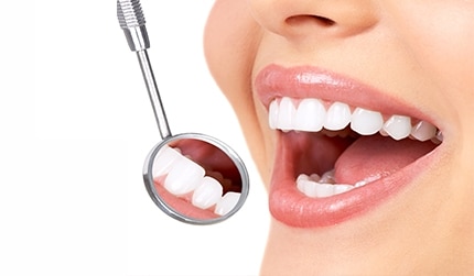 A dental mirror reflecting the front teeth.