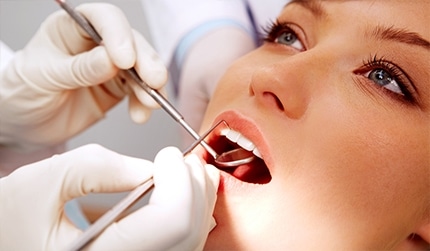 Dental examination with a mirror and dental instruments.