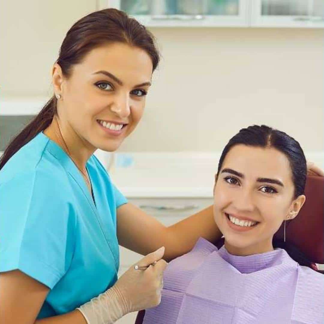 A dental professional and a patient in a treatment chair.