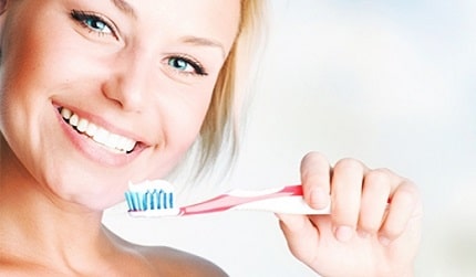 A woman brushing her teeth.