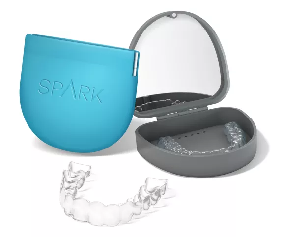 Spark clear aligners with blue and grey storage cases.