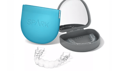 Spark aligners beside their storage cases.